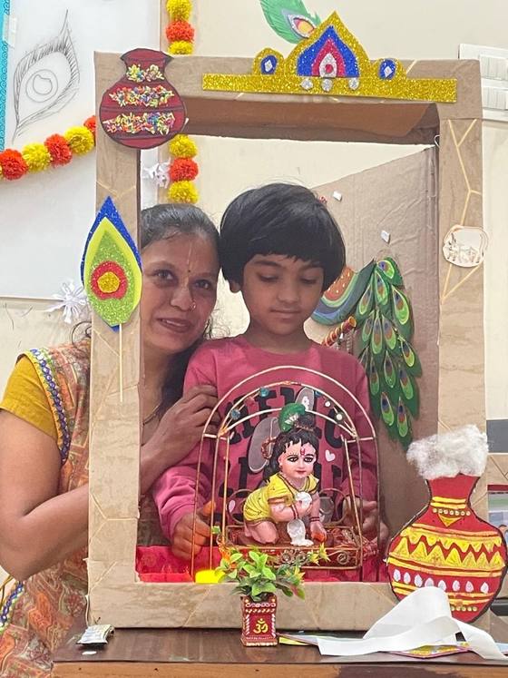 A teacher and child at a handmade festival craft frame